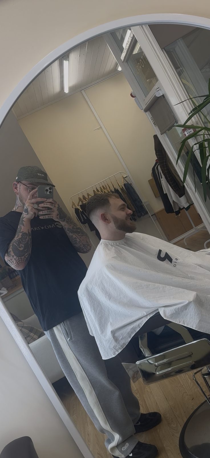 A haircut in progress, reflected in the arched mirror