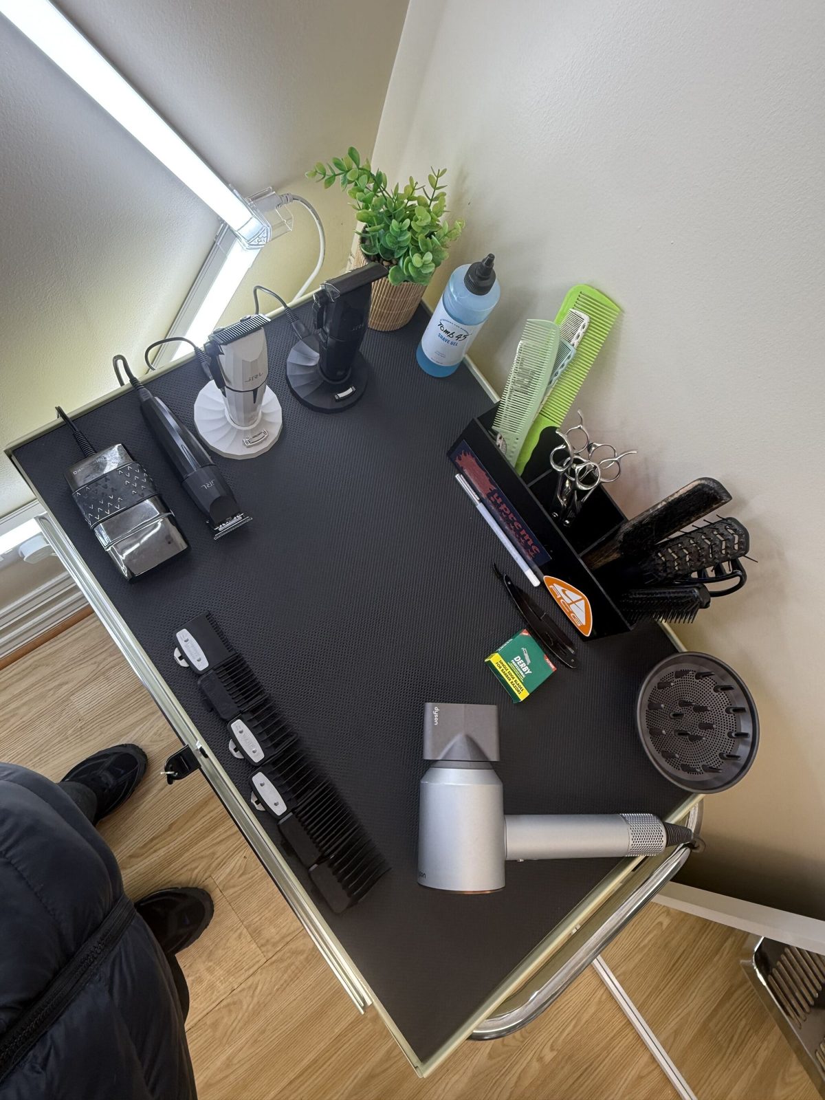 The workstation: clippers, combs, a dryer and a plant