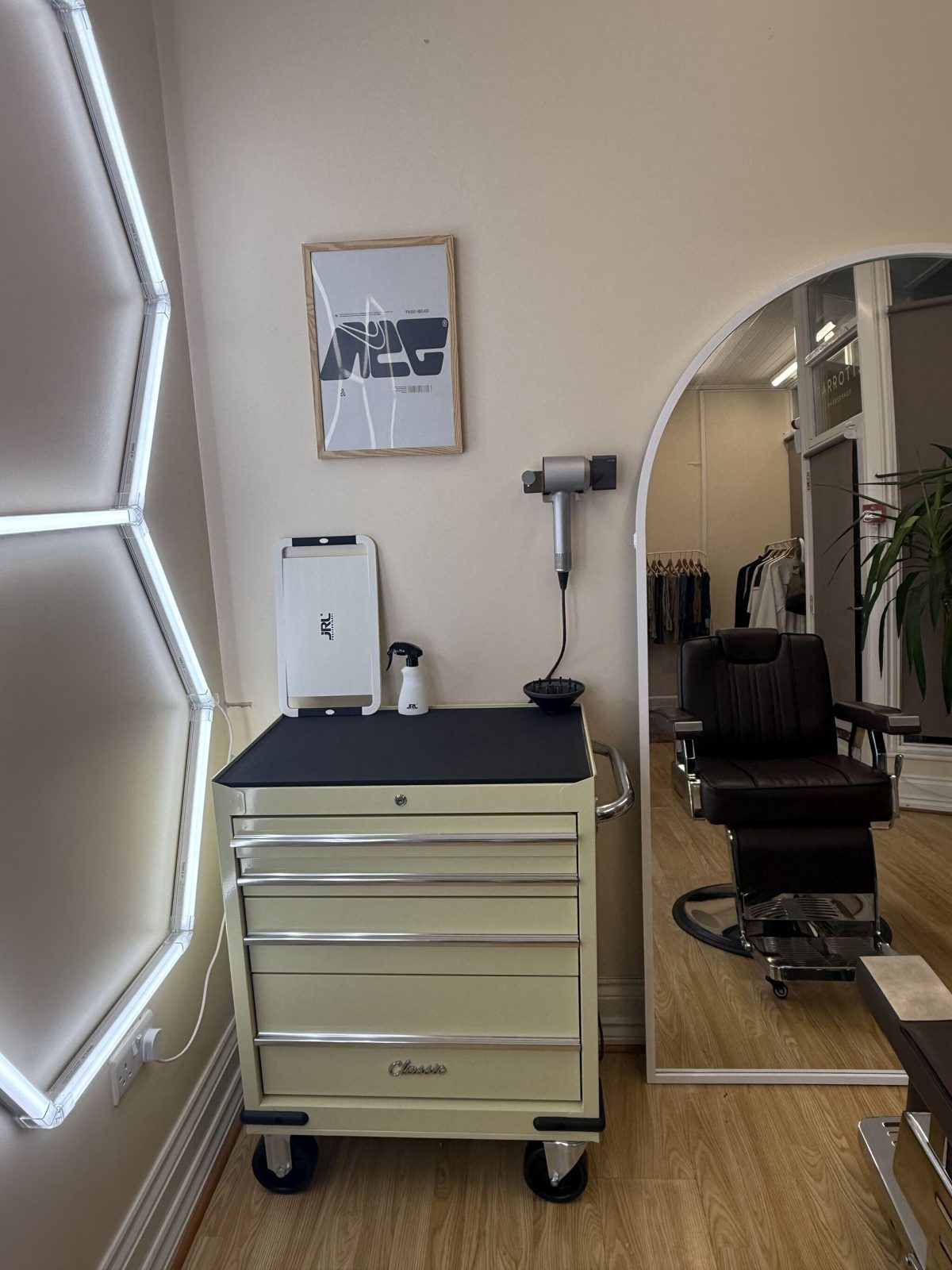 The cream trolley, a hairdryer on the wall and the chair by the mirror